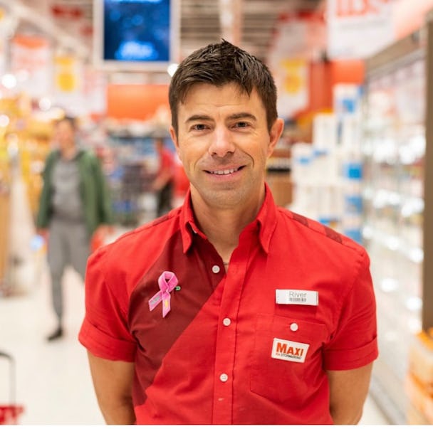 En man i en röd skjorta som står i en livsmedelsbutik.