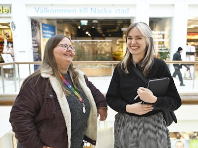 Två kvinnor står i ett köpcentrum.