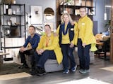 En grupp människor i gula jackor poserar i en möbelbutik.