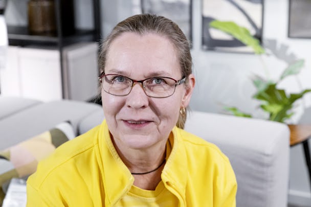 En kvinna som bär glasögon och en gul skjorta.