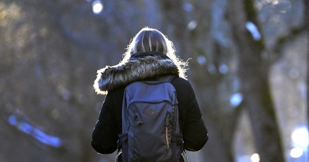 Kvinna med ryggsäck i en park.