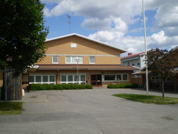 Bild på ingången till anstalten i Gävle, en gul tegelbyggnad.
