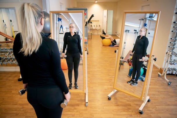 Amanda Bäckström står framför två speglar och tränar med hantlar.