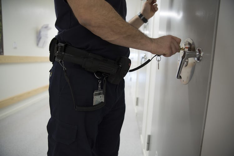 En kriminalvårdare låser dörren till en häktescell