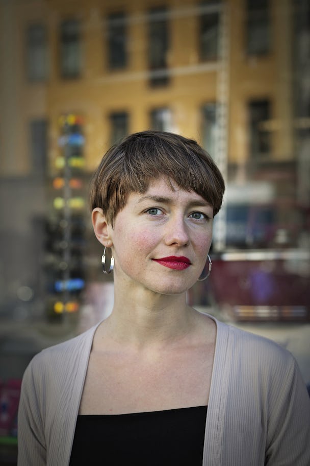 Porträttbild på Anna i kort frisyr i stadsmiljö.