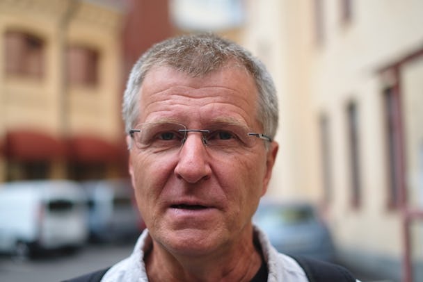 Porträttbild på Rainer Andersson med suddig stadsmiljö i bakgrunden.