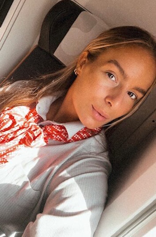Selfie på tågvärden Evelina Wacklin inuti ett Mälartåg, iklädd en vit arbetsskjorta och en röd scarf från Mälartåg.