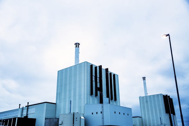 Reaktor 1 vid Forsmarks kärnkraftverk, en kantig byggnad klädd i vit plåt med en skorsten som sticker upp.