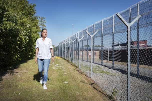Monika Eriksson utanför stängslet till anstalten Ystad en somrig dag.