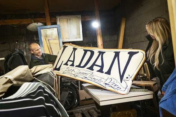 Snickaren Petter Skagaard och Malin Enström håller upp en skylt där det står ”Ladan”.