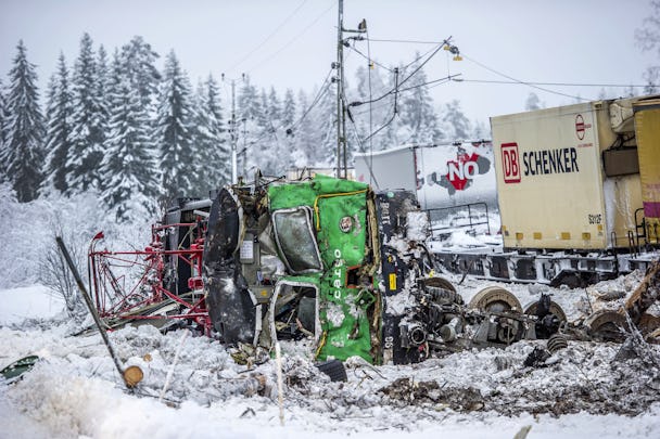 Ett totalkvaddat lok från Green Cargo ligger på sidan i snön bredvid spåret efter att ha kolliderat med en lastbil.