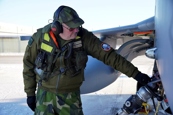 Jan Salomonsson, flygtekniker på Försvarsmakten, står i kamouflagekläder vid ett stridsflygplan.
