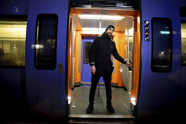 Kundvärden Mazen står inne i ett tåg med öppna dörrar och trycker på en knapp.