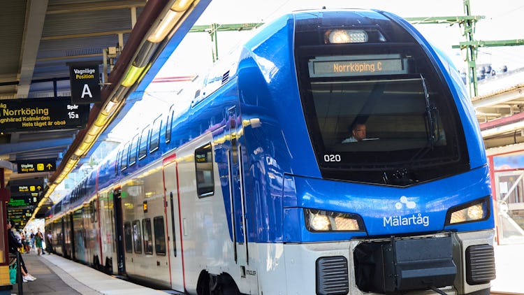 Ett tåg från Mälartåg står inne på perrongen. Tåget är på väg mot Norrköping, framgår av skyltarna.