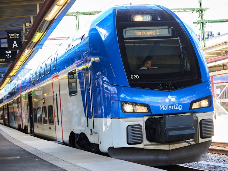 Ett tåg från Mälartåg står inne på perrongen. Tåget är på väg mot Norrköping, framgår av skyltarna.