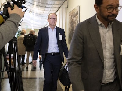 Jonas Abrahamsson går genom en korridor med en kameraoperatör i förgrunden och en annan person till höger.