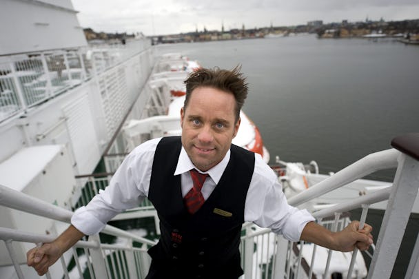 Håkan Hallin står på trapporna till ett fartyg. I bakgrunden syns vattnet och en stadsbild.