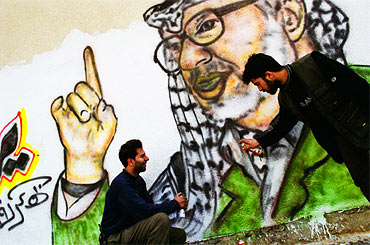 Bröderna Bahaa och Dia al-Qidra gör ett porträtt av Yasir Arafat (2004). Bahaa var Arafats egen graffitikonstnär.
