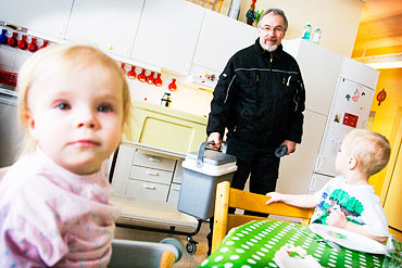 Vaktmästaren Gösta Widell kommer med matboxar till Småbarnsskolan Mullvaden, där Sally, 1 år och Vilmer, 3 år, väntar på att få äta.