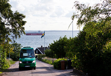 Från Kyrkviken på Vens västra kust klättrar bussen upp för backafallen. I bakgrunden syns Danmark.