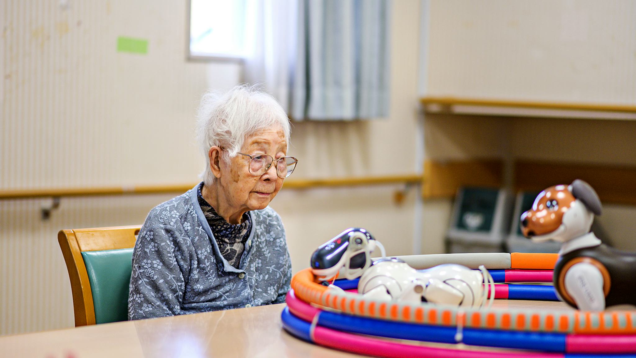 Hundraåriga Kisa Okubu som bor på äldreboendet Shintomi med robothunden Aibo.