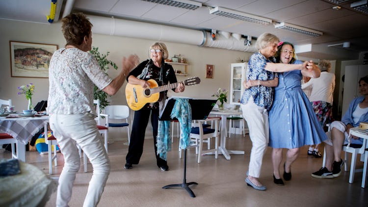 Sylvia Sandin spelar gitarr för äldre personer.