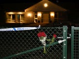 Blommor vid grinden till vårdboendet i Enköping där en ung kvinna i personalen dödades på torsdagen.