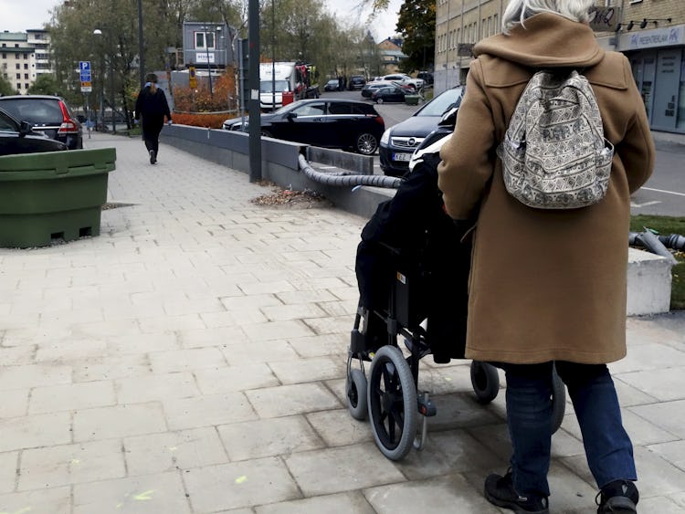 Kvinna i rullstol får hjälp av sin personliga assistent.