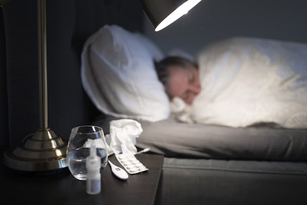 Bild på en sjuk person som ligger i sängen.