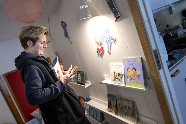 Barnskötaren Anna Wernqvist ställer tillbaka några barnböcker i bokhyllan.