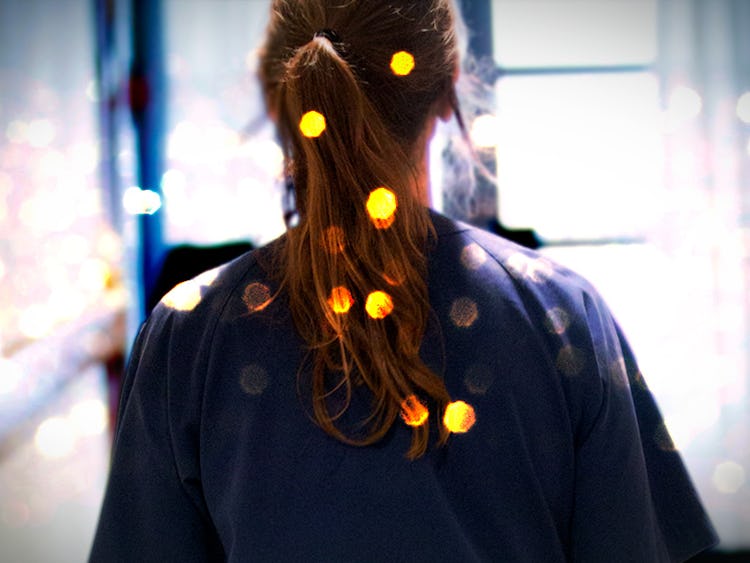 En undersköterska med ljusflimmer i håret går i en korridor