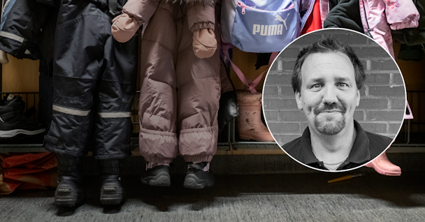 Dennis Persson inklippt framför ett ställ med barnkläder.