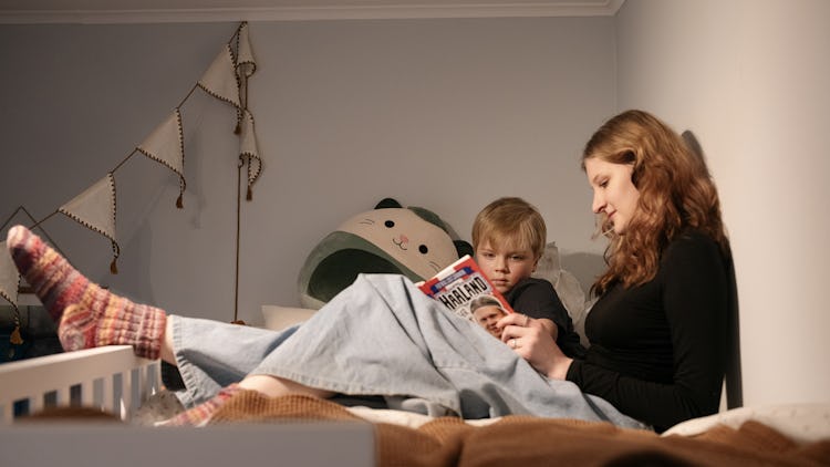 Cecilia Ahnberg och Albert Aaröe sitter i en säng och läser en bok.