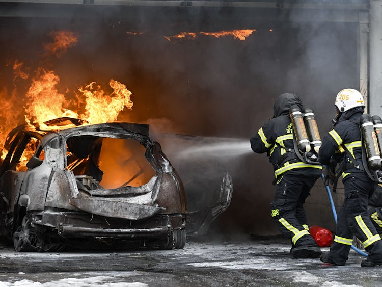 En grupp brandmän bekämpar en brand i ett garage.
