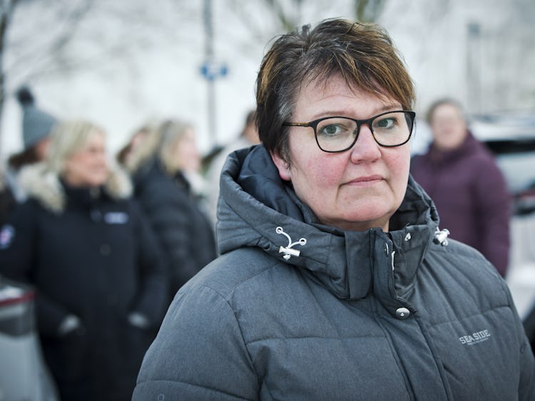 Stina Eriksson i glasögon som står framför parkerade bilar.