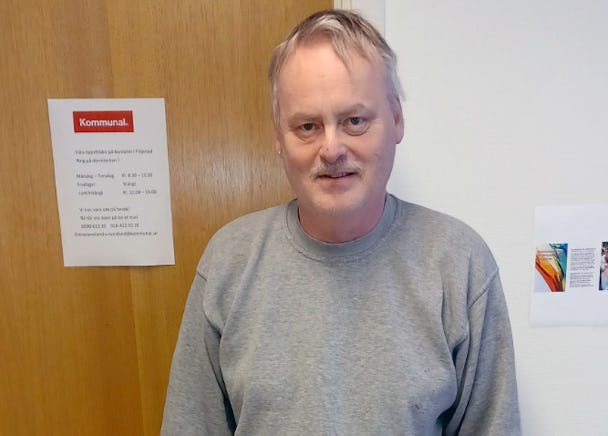 Dan Stjernlöf i en grå tröja som står framför en dörr.