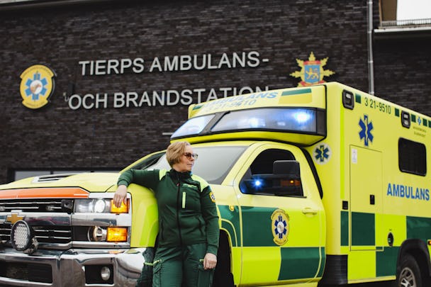 En sjukvårdare står bredvid en ambulans.