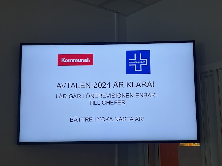 Digital display som tillkännager "avtal 2024 är klart! i år är lönerevision endast för chefer. bättre lycka nästa år!" på svenska, med logotyper för kommunal och en andra organisation.