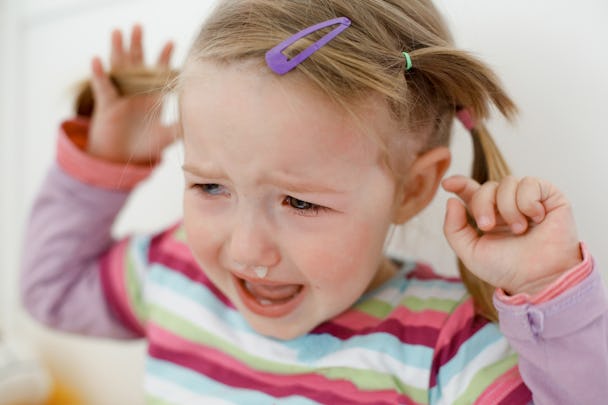 Ett litet barn som gråter med en tår rullande nerför hennes kind.