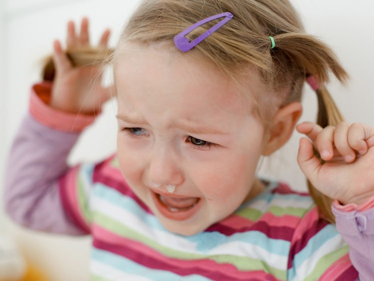 Ett litet barn som gråter med en tår rullande nerför hennes kind.