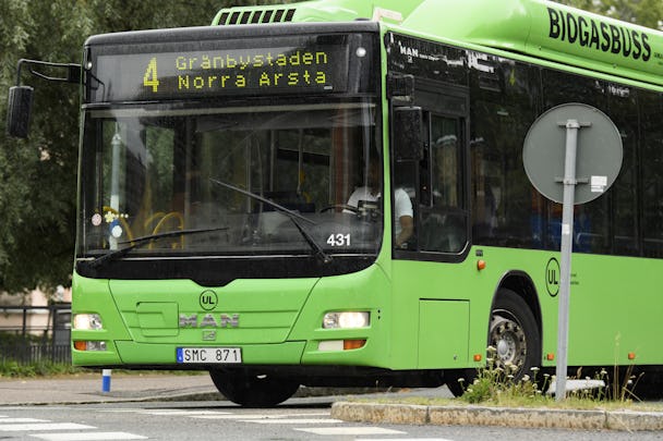 En grön biogasdriven buss med rutt nummer 4 och destination Gränby på fronten svänger höger i en korsning.