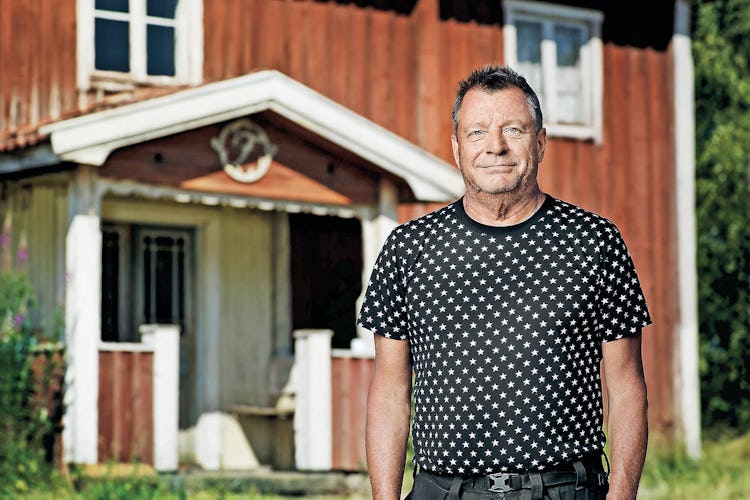 Göran står framför ett rött lantligt hus