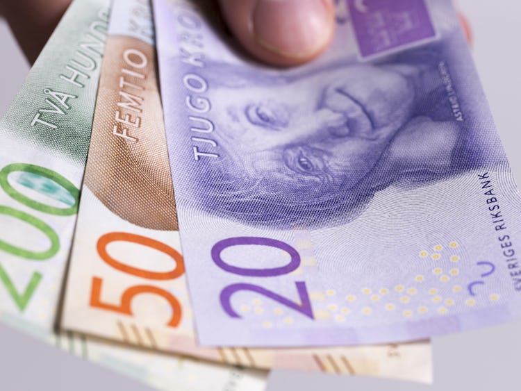 En hand som håller i svenska sedlar