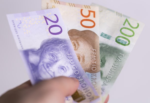 En hand som håller i svenska sedlar