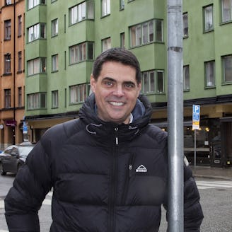 Mikael Pettersson står i täckjacka på en stadsgata.