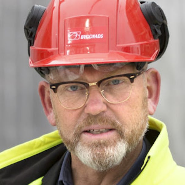 Porträttfoto på Johan Lindholm i röd bygghjälm