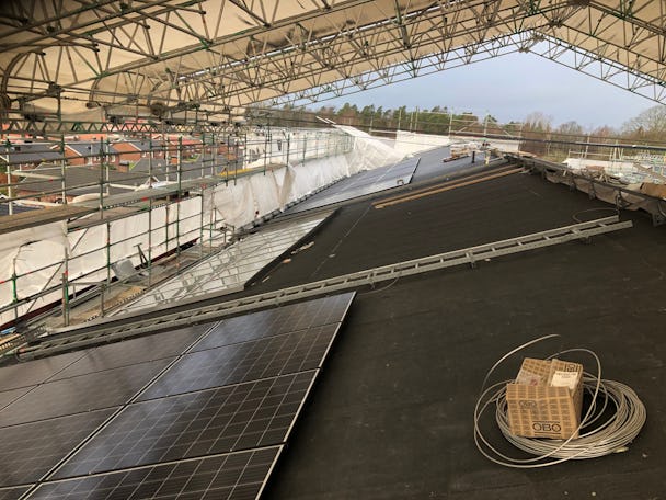 Ett stort utrymme under tak, med solceller och optimerare
