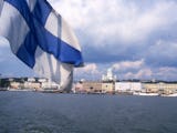 Helsingfors skyline, vatten och den finska flaggan