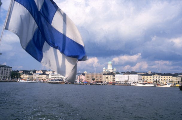 Helsingfors skyline, vatten och den finska flaggan