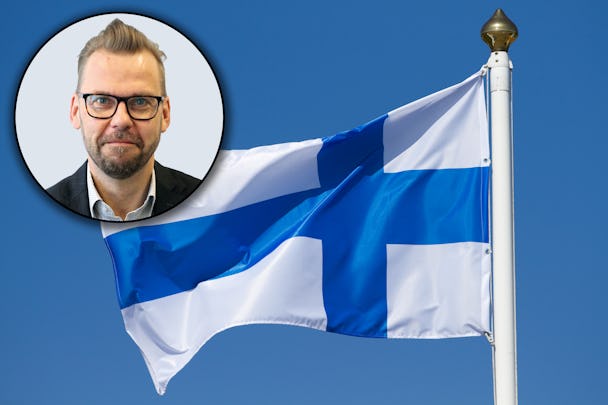Den finska flaggan med en porträttbild av Jari Ollila monterad över
